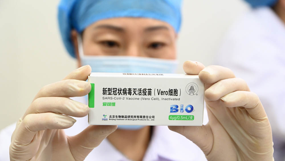 图为工作人员展示中国产新冠病毒灭活疫苗.(图片来源:中新社)